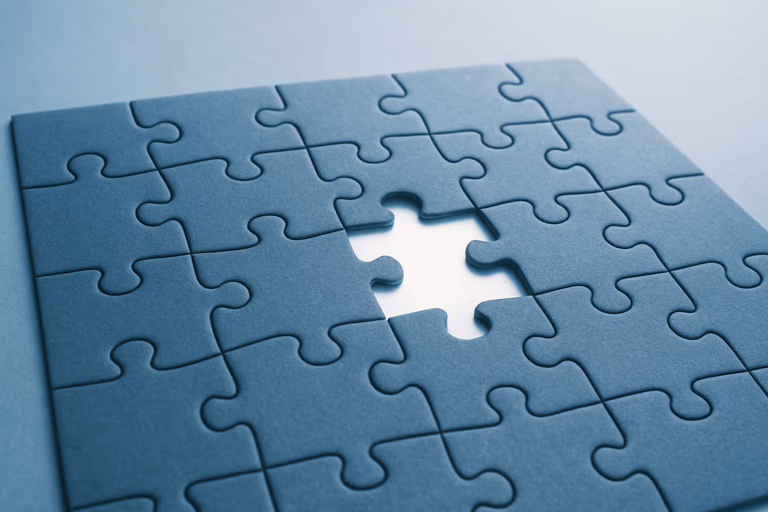 image of a dark blue puzzle with one piece missing in the middle